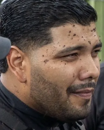 Rostro de un policía estatal sin capucha, con la cara salpicada de lodo